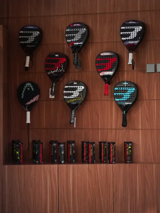 Padel rackets on a timber wall