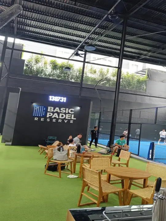 Seating on green turf beside the court